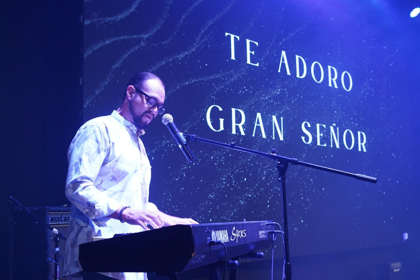 Omar Vigil al teclado frente a la pantalla con la letra «Te adoro, gran Señor»