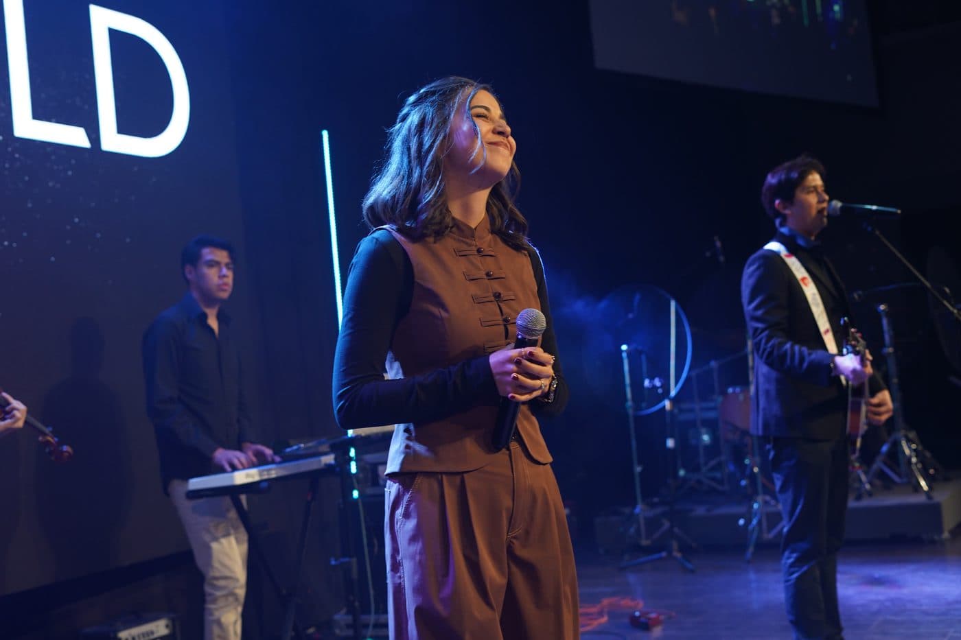 María Teomitzi cantando junto a Aldo, de Songfield, con su bajo en el escenario